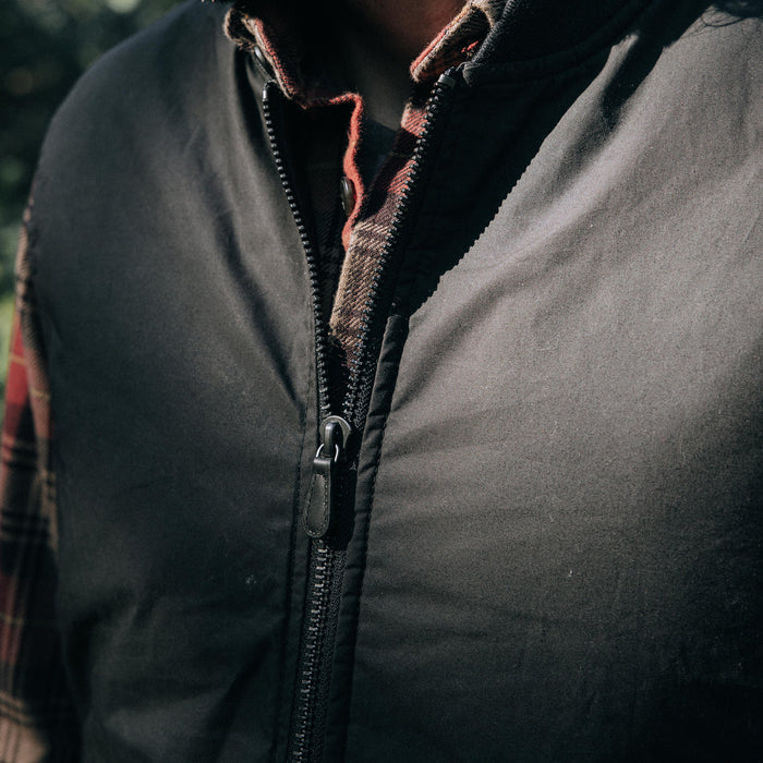 fit model showing off zipper on The Ignition Vest in Coal Dry Wax
