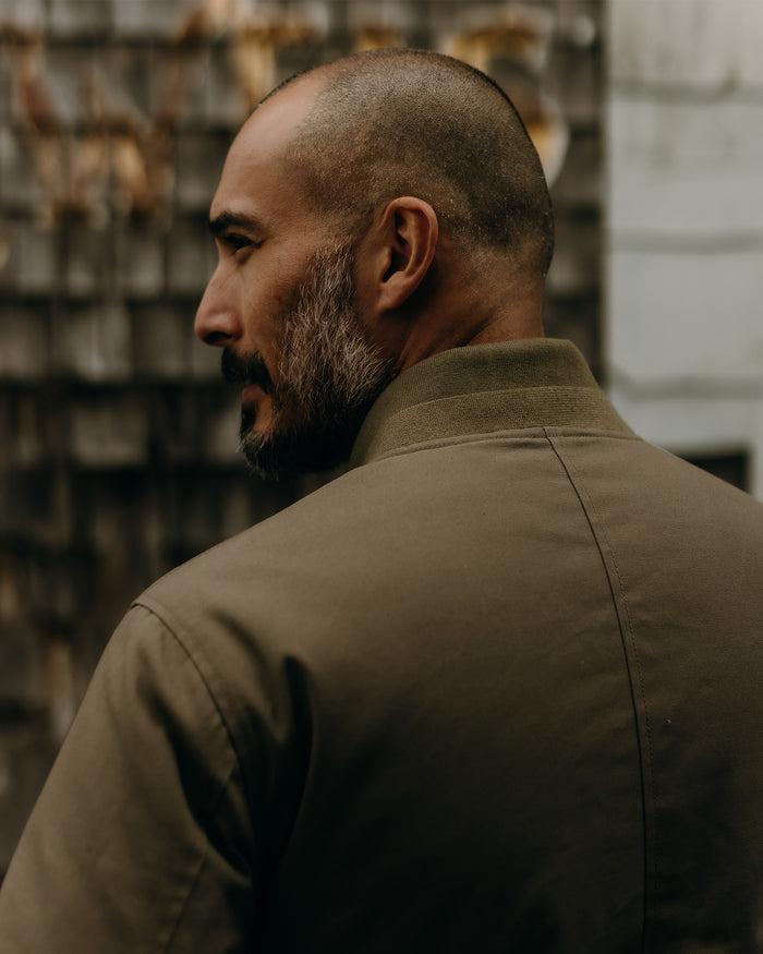 fit model wearing The Insulated Bomber Jacket in Fatigue Olive Dry Wax with water beading on the surface