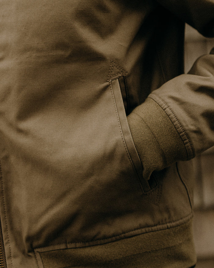 fit model walking in The Insulated Bomber Jacket in Fatigue Olive Dry Wax
