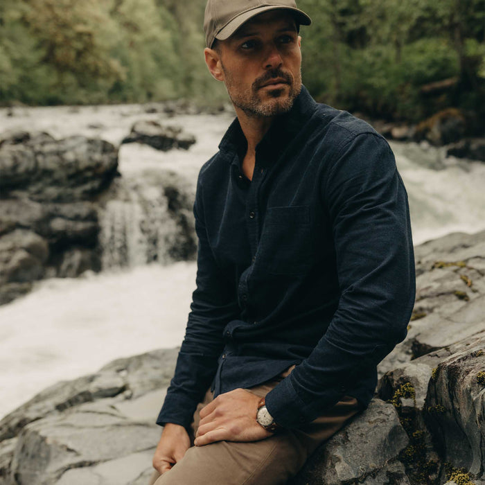fit model sitting on a rock wearing The Jack in Heather Marine Pincord
