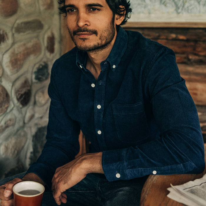 fit model wearing The Jack in Indigo Cord, sitting holding coffee