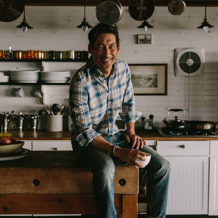 fit model wearing The Jack in Melange Navy Plaid, sitting on table drinking coffee