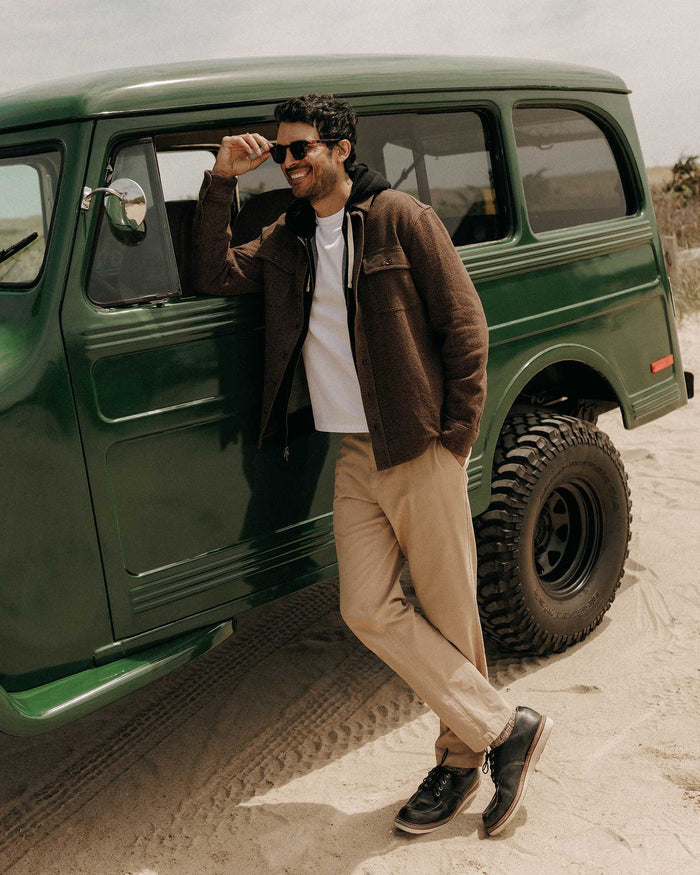 fit model leaning against a car wearing The Ledge Shirt in Black Coffee Linen Tweed