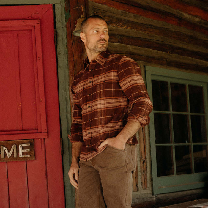 fit model leaning against the wall wearing The Ledge Shirt in Chestnut Plaid