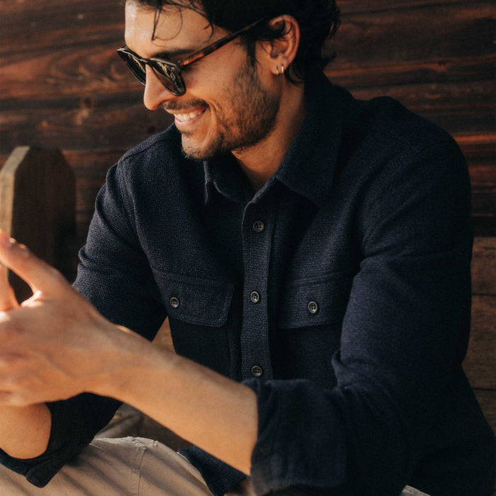 fit model sitting wearing The Ledge Shirt in Dark Navy Linen Tweed