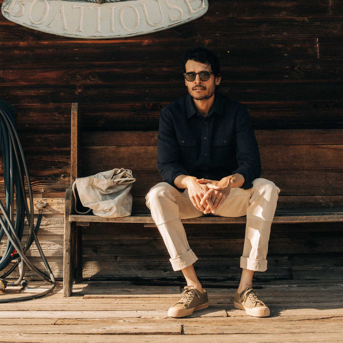 fit model sitting on a bench in The Ledge Shirt in Dark Navy Linen Tweed