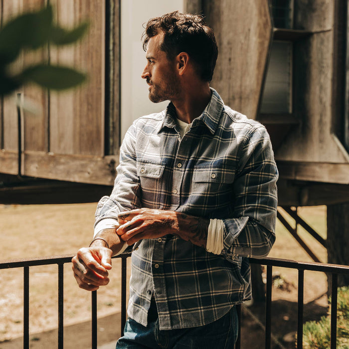 fit model wearing The Ledge Shirt in Navy Plaid, cuffed, looking left