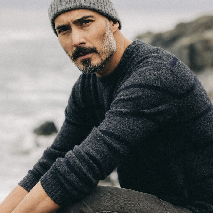 fit model sitting in The Lodge Sweater in Charcoal Stripe