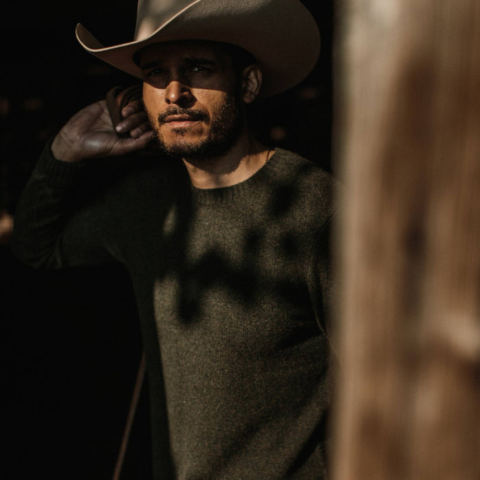 fit model wearing the lodge sweater, looking into camera wearing hat