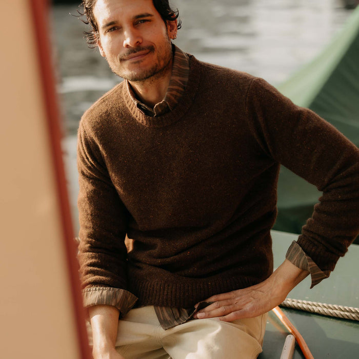 fit model sitting wearing The Lodge Sweater in Timber Donegal