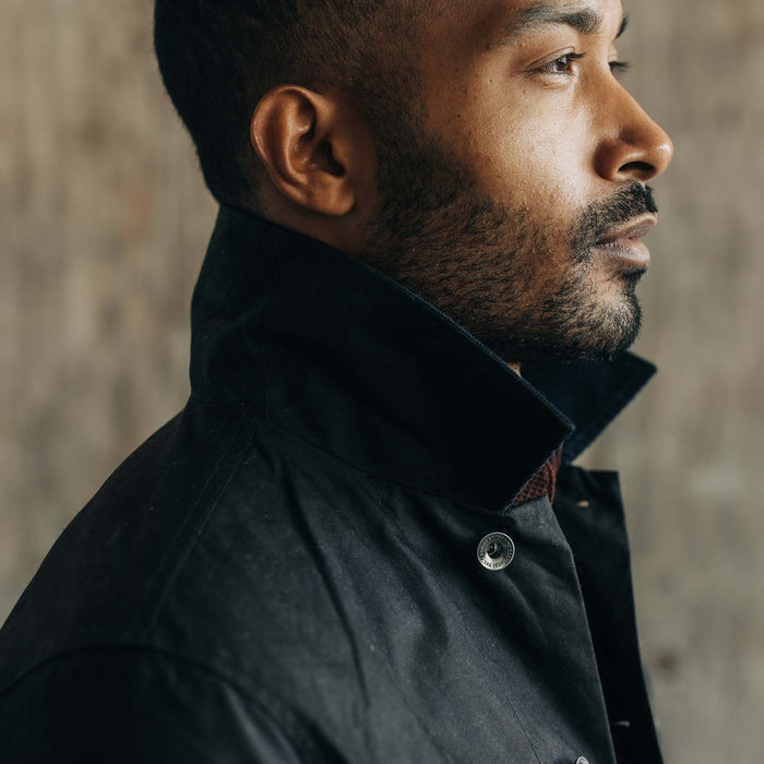 fit model with his collar popped up wearing The Long Haul Jacket in Coal Waxed Canvas