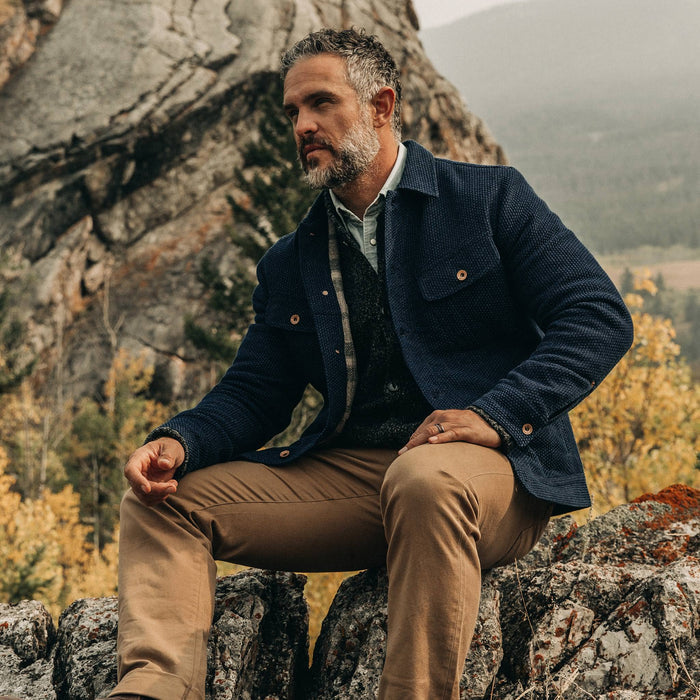 fit model wearing The Long Haul Jacket in Indigo Sashiko—sitting on rock