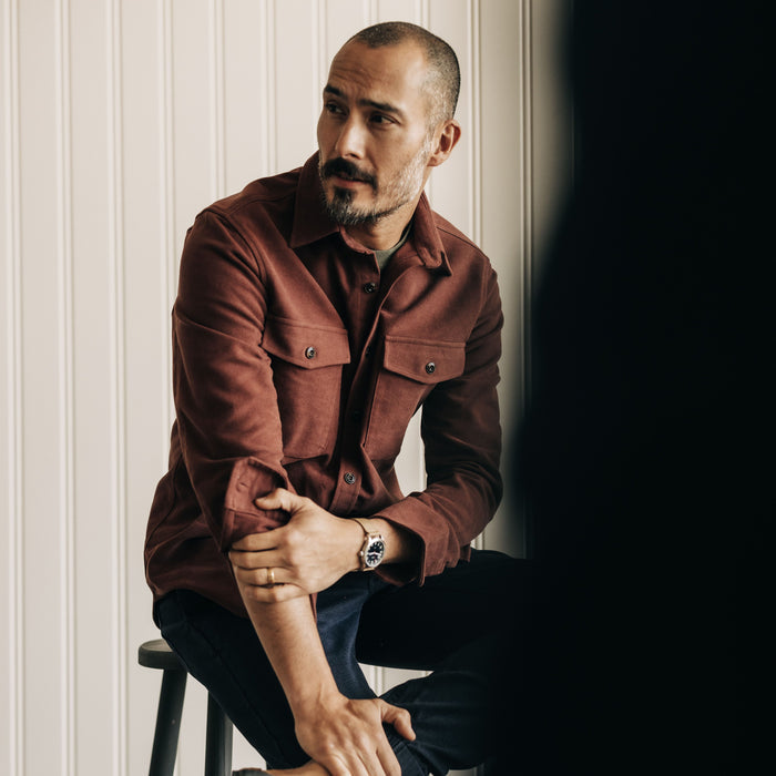 fit model sitting in The Maritime Shirt Jacket in Black Cherry Moleskin