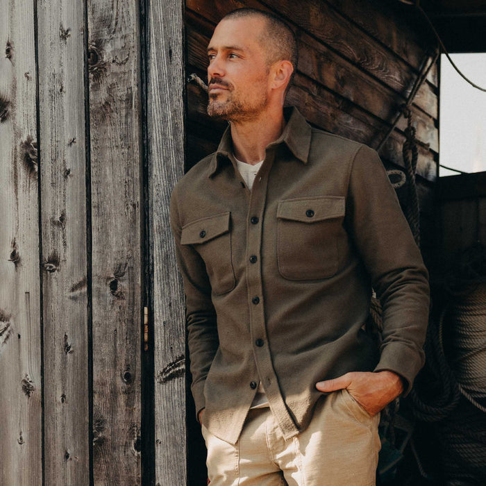 fit model leaning against the wall wearing The Maritime Shirt Jacket in Fatigue Olive Moleskin Twill