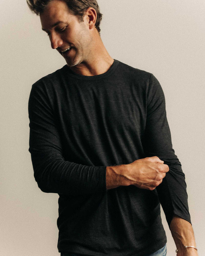 fit model posing in The Merino Long Sleeve Tee in Heather Black
