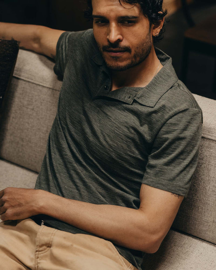fit model sitting wearing The Merino Polo in Heather Army