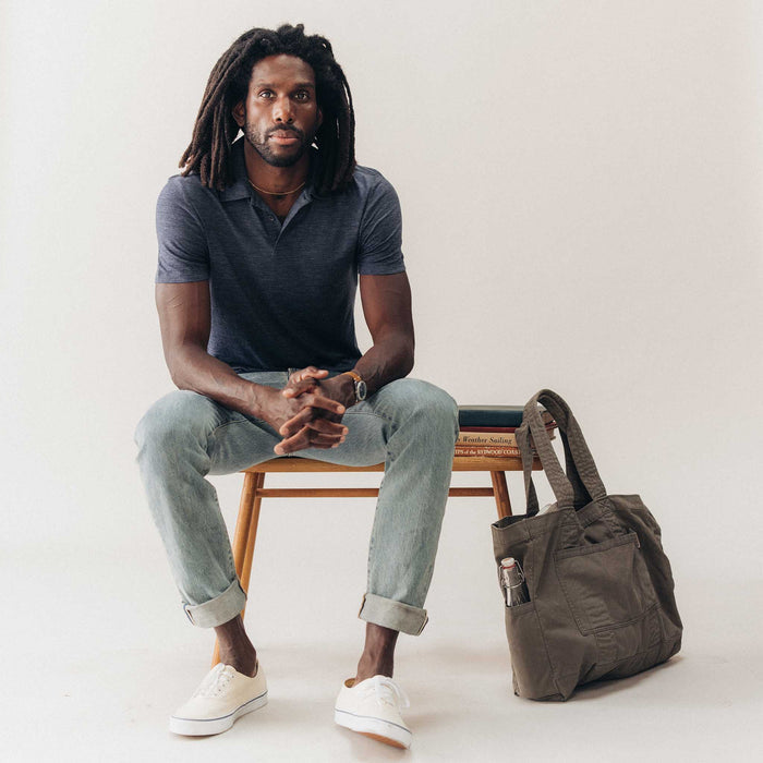 fit model sitting wearing The Merino Polo in Heather Navy
