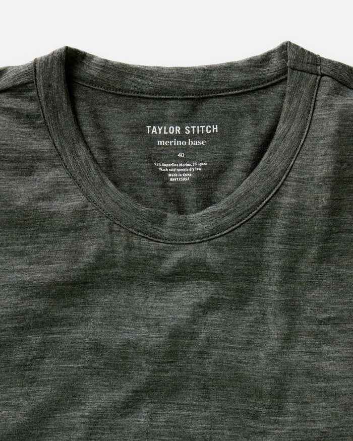 fit model lying on the ground wearing The Merino Tee in Heather Army