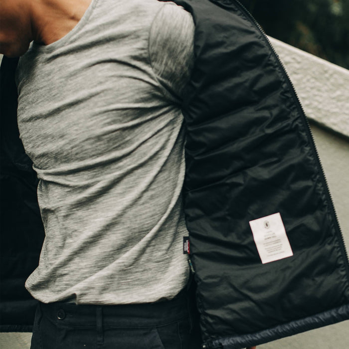 our fit model wearing The Merino Tee—in our grey colorway paired with a jacket