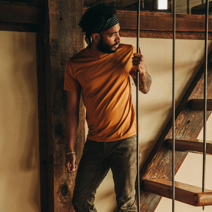 fit model wearing The Merino Tee in Heather Saffron, looking right