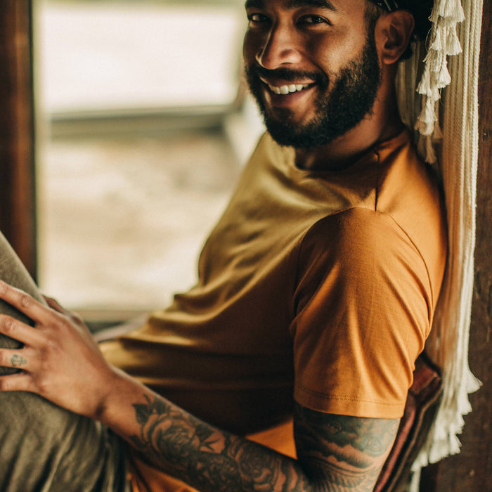fit model wearing The Merino Tee in Heather Saffron, reclining, shoulder detail