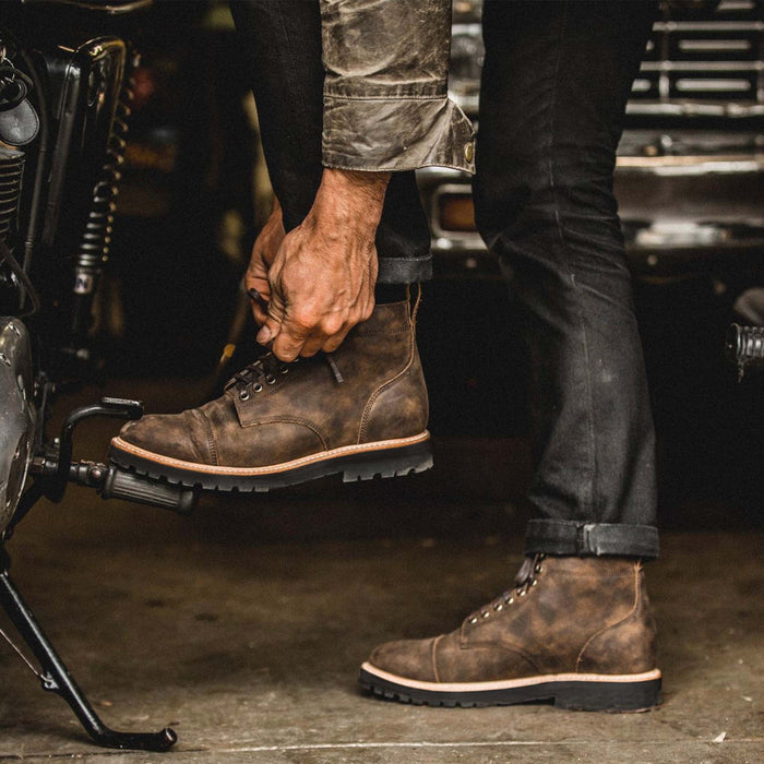 fit model tying the shoelace of The Moto Boot in Espresso Grizzly