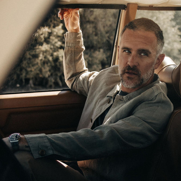 fit model sitting in a vintage car in The Ojai Jacket in Arid Eucalyptus Hemp