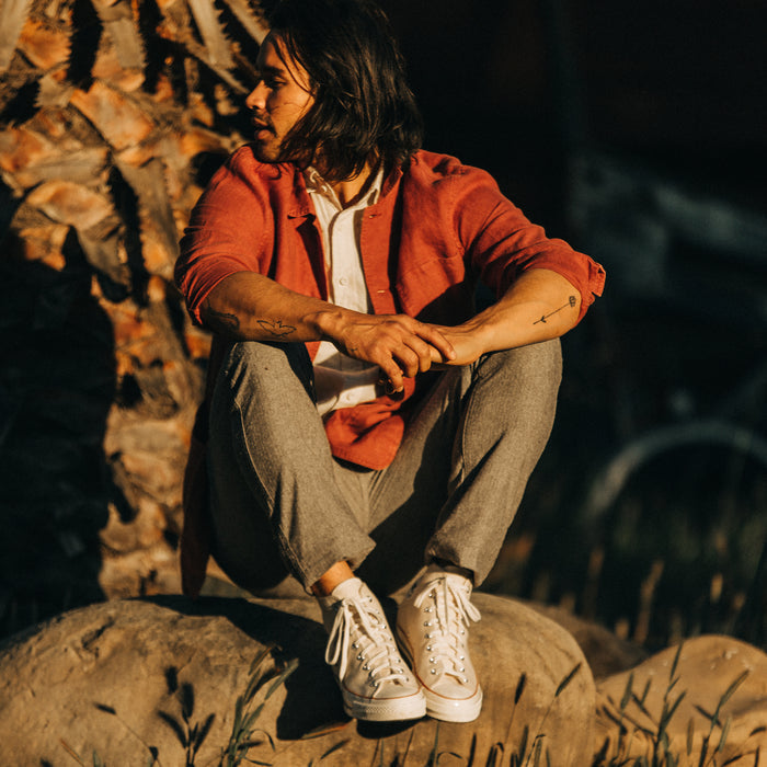 fit model sitting in The Ojai Jacket in Rust Hemp