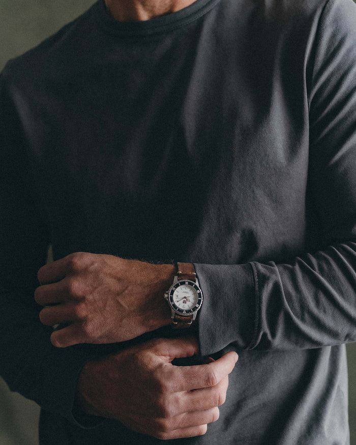 fit model adjusting the cuffs on The Organic Cotton Long Sleeve Tee in Faded Black