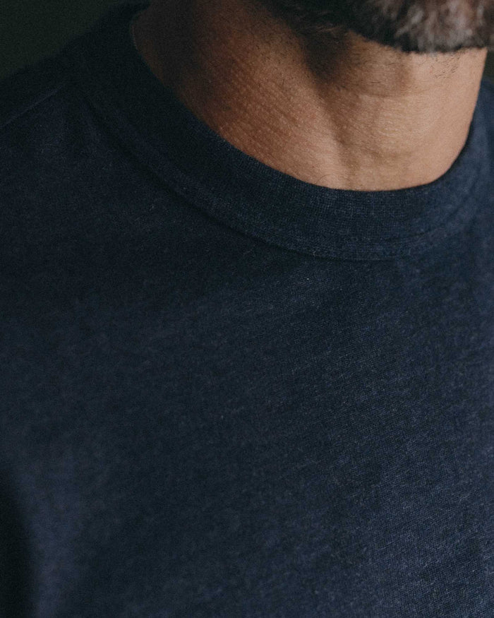 fit model with his hands folded wearing The Organic Cotton Shop Tee in Navy Twist