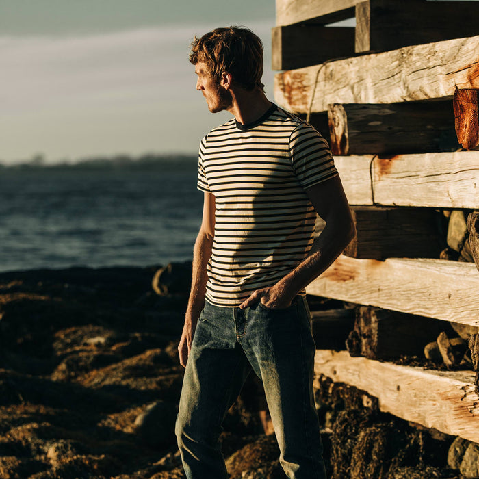 fit model wearing The Organic Cotton Tee in Gold Stripe, on rocks