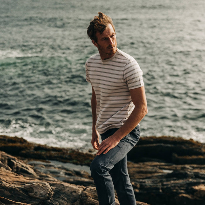 fit model wearing The Organic Cotton Tee in Graphite Stripe, near coast