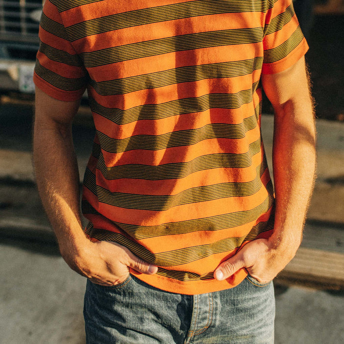 fit model standing in the sun in The Organic Cotton Tee in Rust Stripe