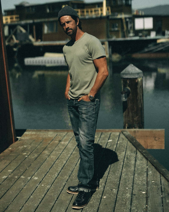 fit model with a jacket over his shoulder wearing The Organic Cotton Tee in Sage