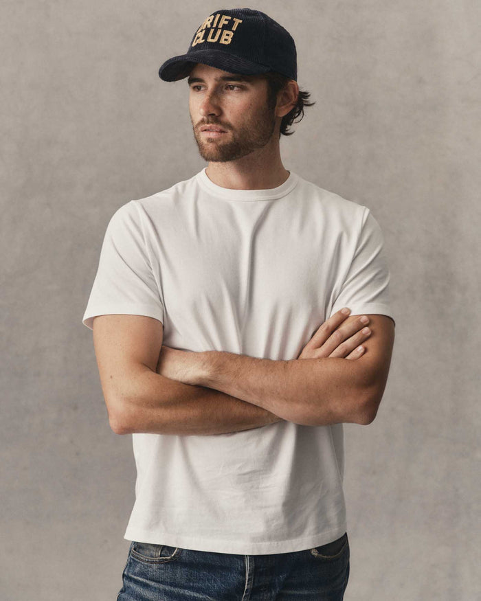 fit model leaning against the wall wearing The Organic Cotton Tee in White
