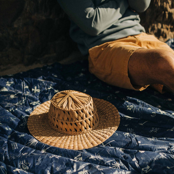 fit model sitting on The Original Puffy Blanket in Navy Aloha