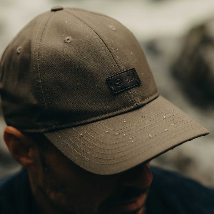 fit model showing off water droplets on The Pathfinder Cap in Fatique Olive Dry Wax