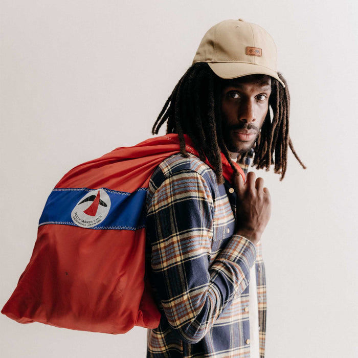 fit model holding a bag wearing The Pathfinder Cap in Khaki Dry Wax