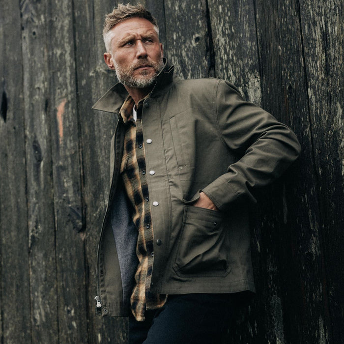 fit model with his hands in the pockets of The Pathfinder Jacket in Fatigue Olive Dry Wax
