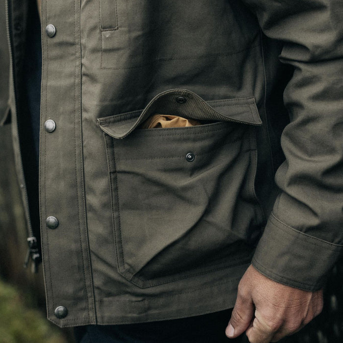 fit model showing off pockets on The Pathfinder Jacket in Fatigue Olive Dry Wax