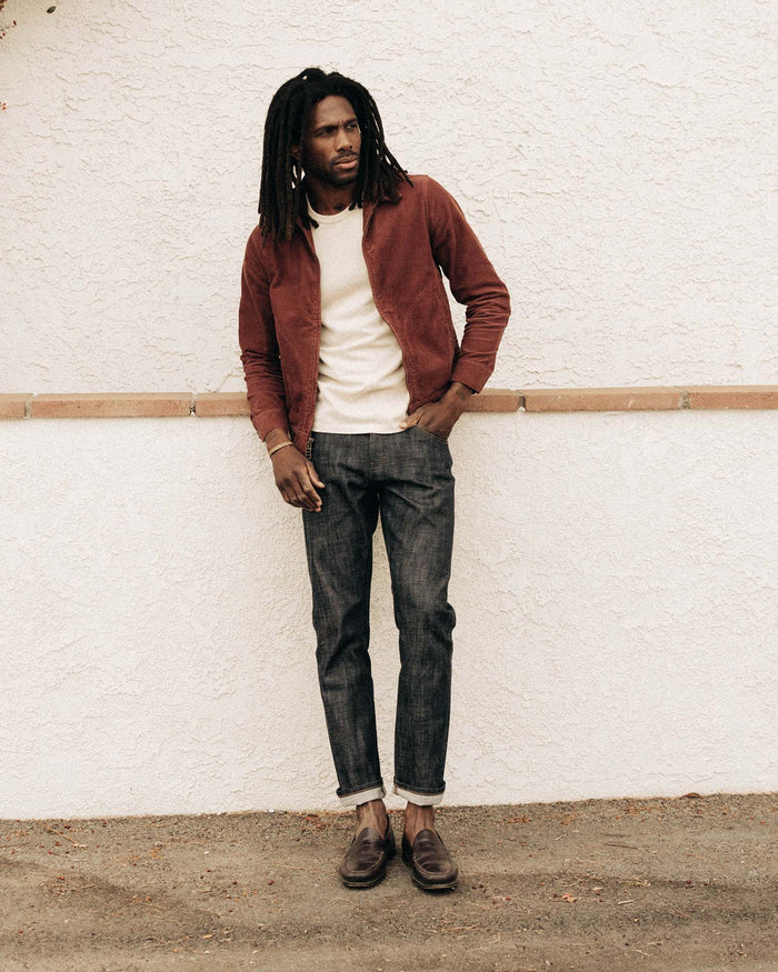fit model leaning against the wall wearing The Piston Jacket in Dried Cherry Corduroy