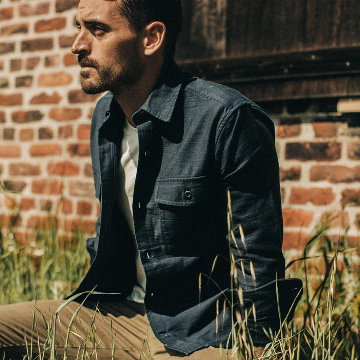 fit model wearing The Point Shirt in Navy Reverse Sateen, sitting in grass
