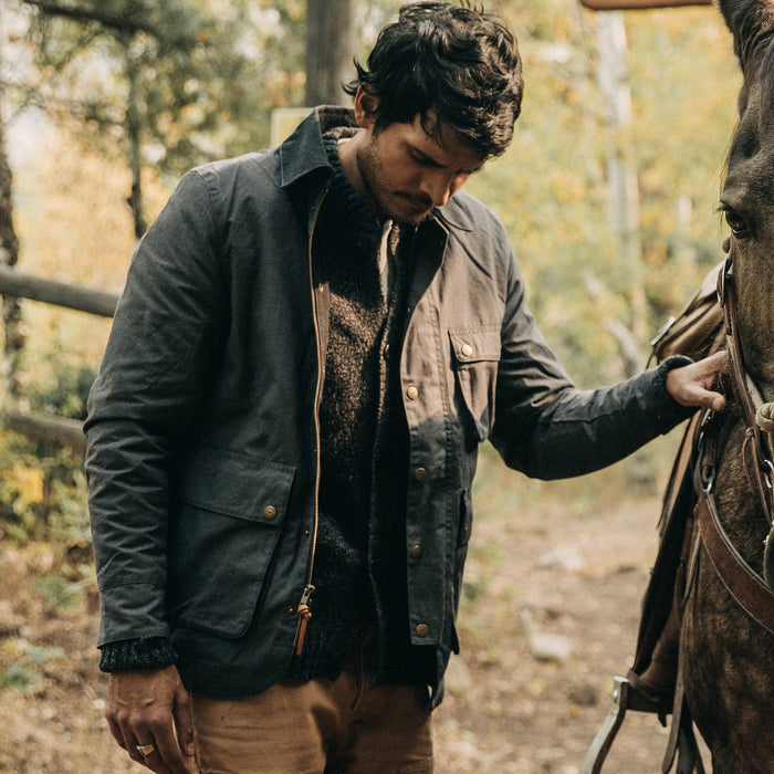 fit model wearing The Rover Jacket in Ripstop Slate Dry Wax, hand on horse