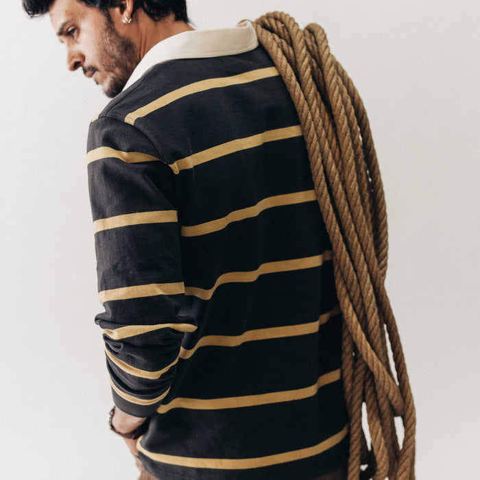 fit model showing off the back of The Rugby Shirt in Faded Black Stripe