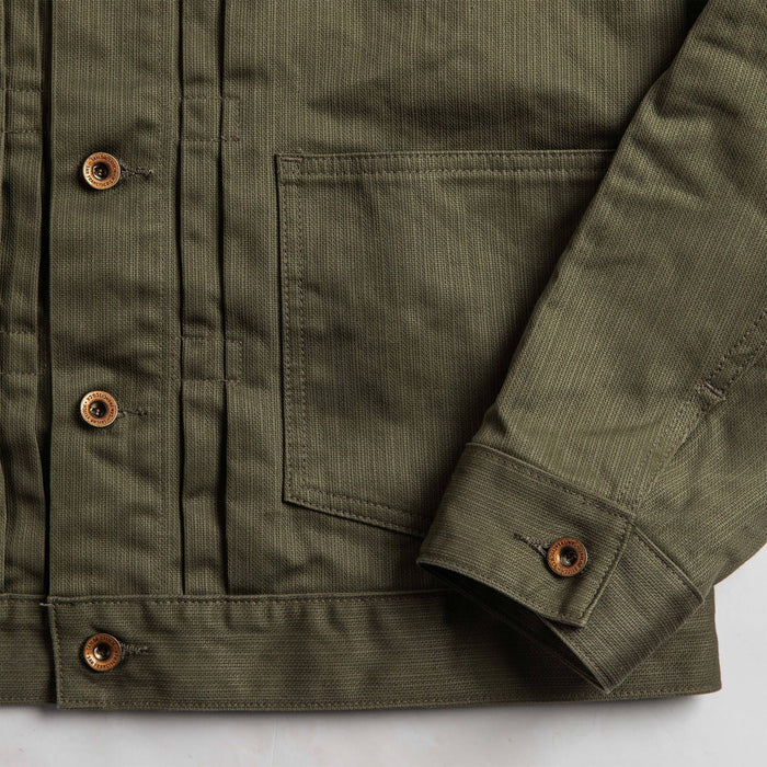 material shot of The Ryder Jacket in Yoshiwa Mills Olive showing front waist pocket and sleeve cuff