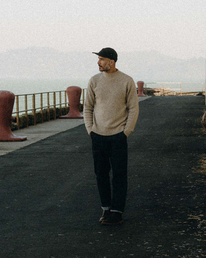 fit model walking wearing The Seafarer Sweater in Natural Donegal