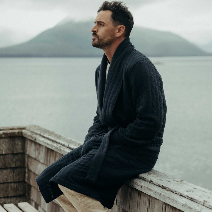 fit model sitting wearing The Shawl Robe in Heather Midnight Quilted Jersey