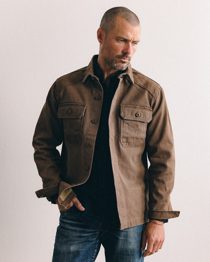 fit model sitting wearing The Shop Shirt in Aged Penny Chipped Canvas