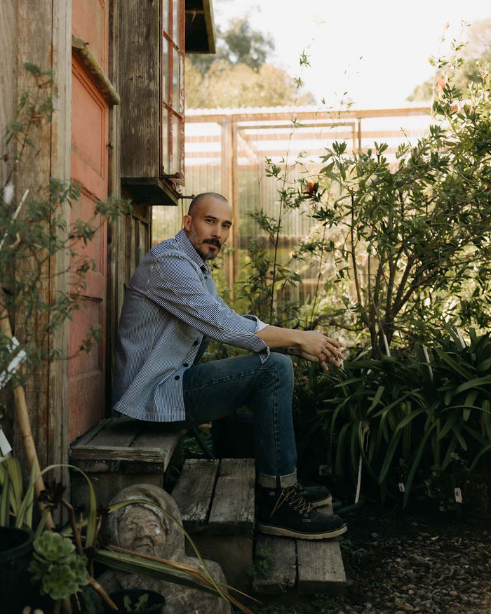 fit model sitting wearing The Shop Shirt in Rinsed Indigo Selvedge