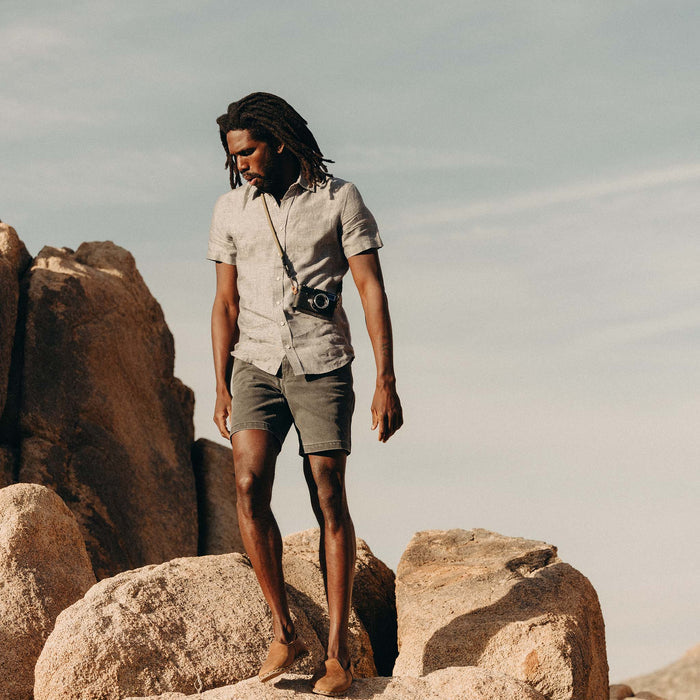 fit model on a rock wearing The Short Sleeve California in Faded Navy Hemp